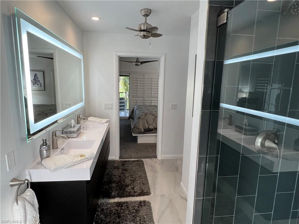 348 Tern Drive, Unit 2 Naples, FL 34112 - Photo 9 of 28 a en suite bathroom with a sink and a mirror