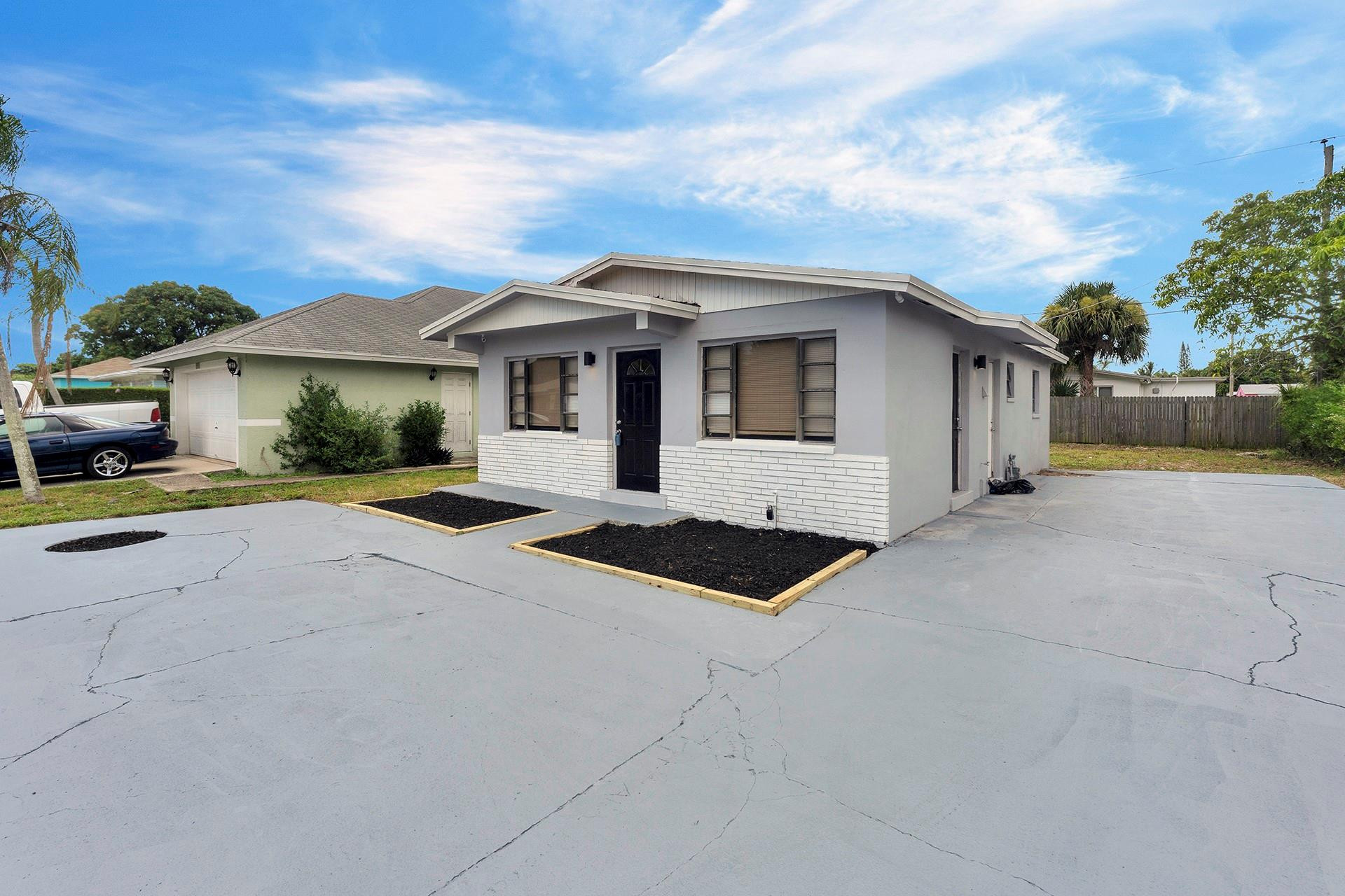 959 West 4th Street Riviera Beach, FL 33404 - Photo 3 of 18 a front view of a house with a yard and garage