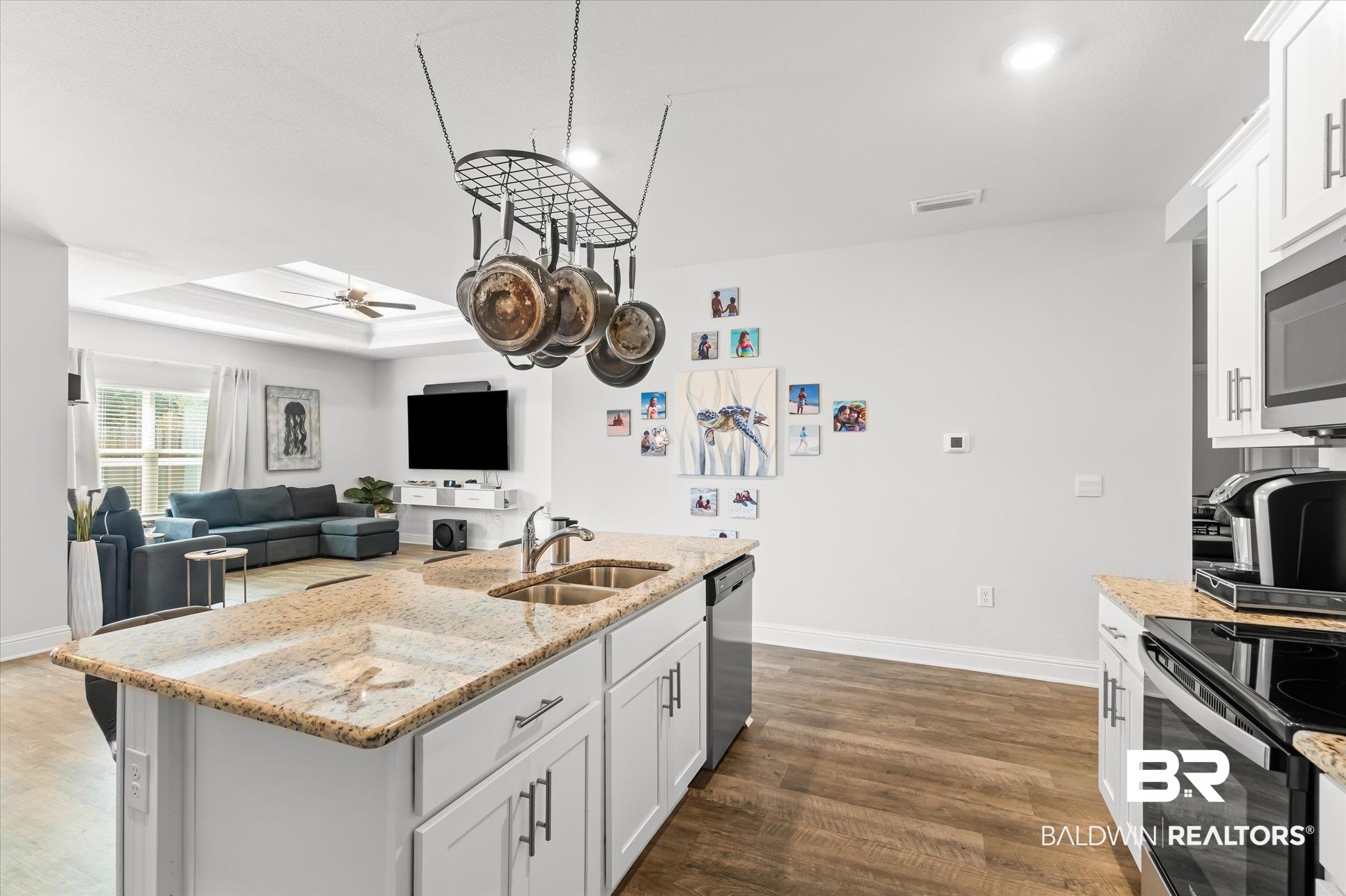 23246 Lieutenant Avenue Foley, AL 36535 - Photo 13 of 36 Kitchen with sink, appliances with stainless steel finishes, an island with sink, white cabinets, and a raised ceiling