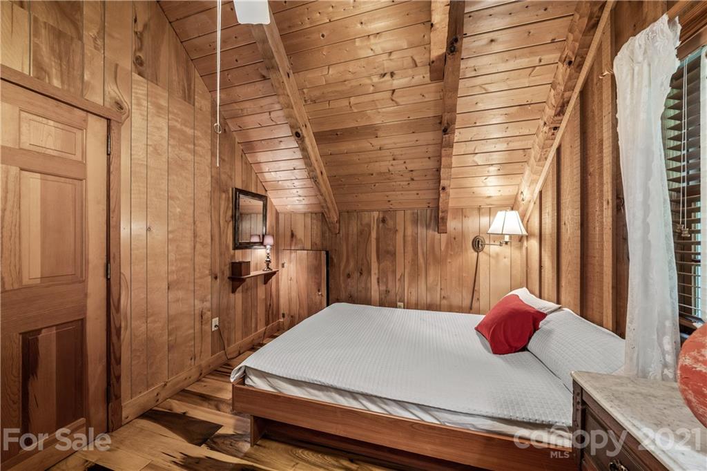 602 Quail Cove Road Clyde, NC 28721 - Photo 22 of 48 a bedroom with a bed and wooden floor