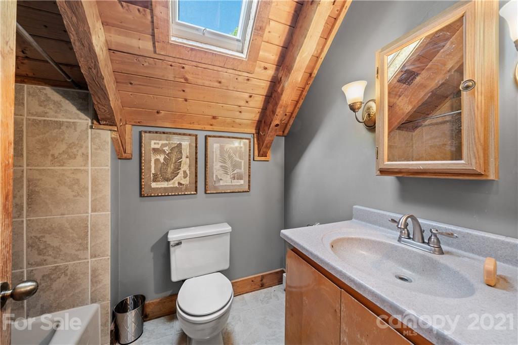 602 Quail Cove Road Clyde, NC 28721 - Photo 23 of 48 a bathroom with a granite countertop toilet sink and mirror