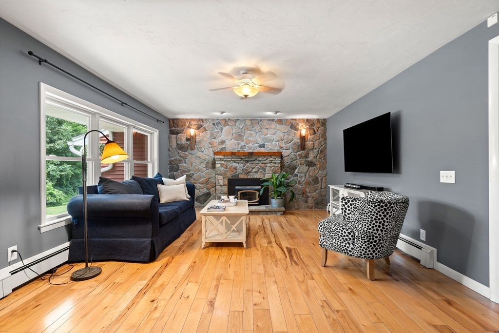 152 Gay Road Groton, MA 01450 - Photo 12 of 38 a living room with furniture a fireplace and a flat screen tv