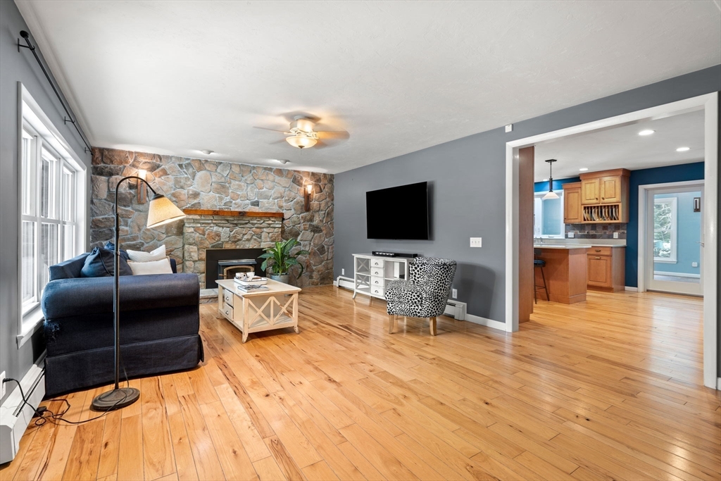 152 Gay Road Groton, MA 01450 - Photo 10 of 38 a living room with furniture a flat screen tv and a fireplace