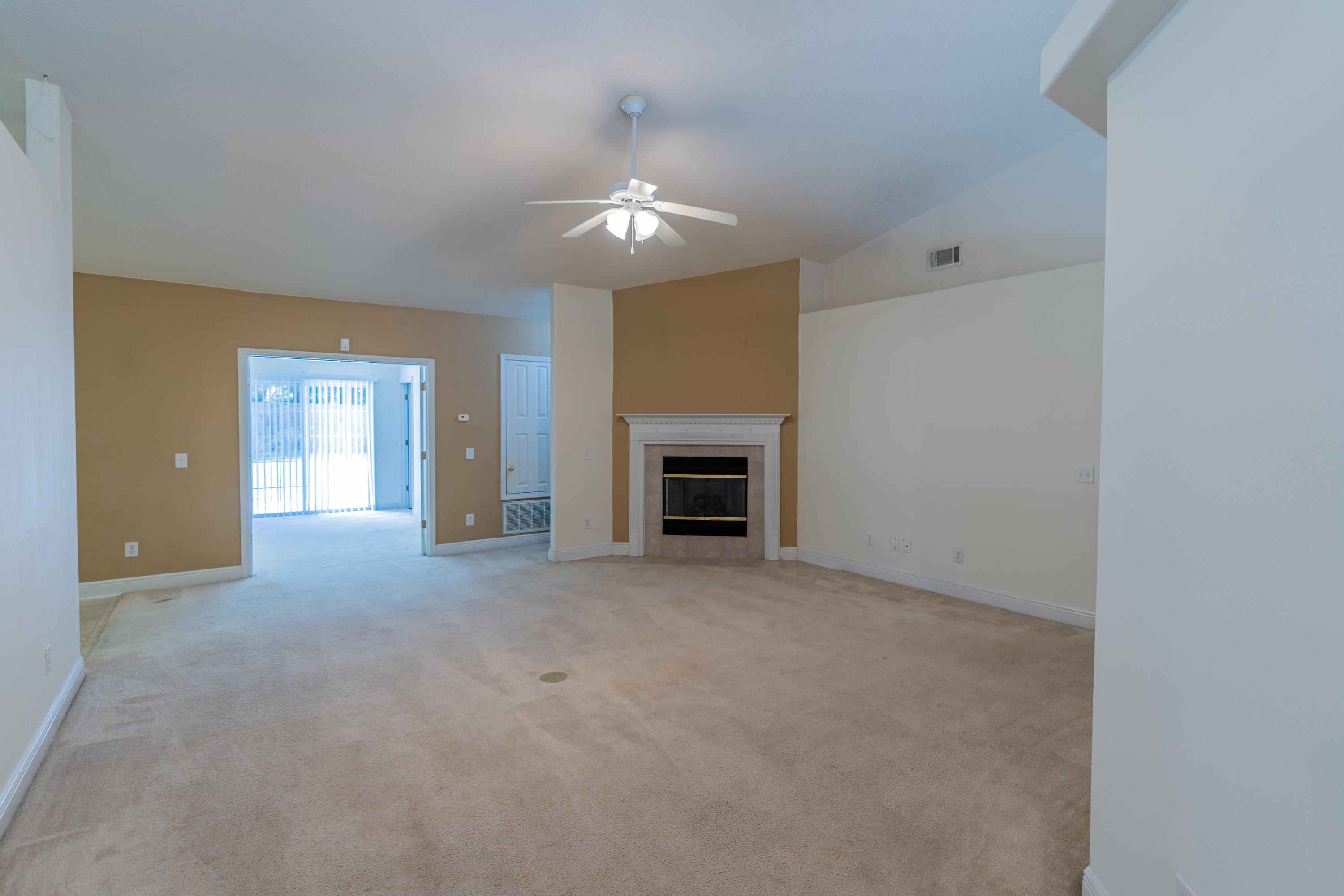 231 Foxchase Way Crestview, FL 32536 - Photo 7 of 30 an empty room with a fireplace and chandelier fan