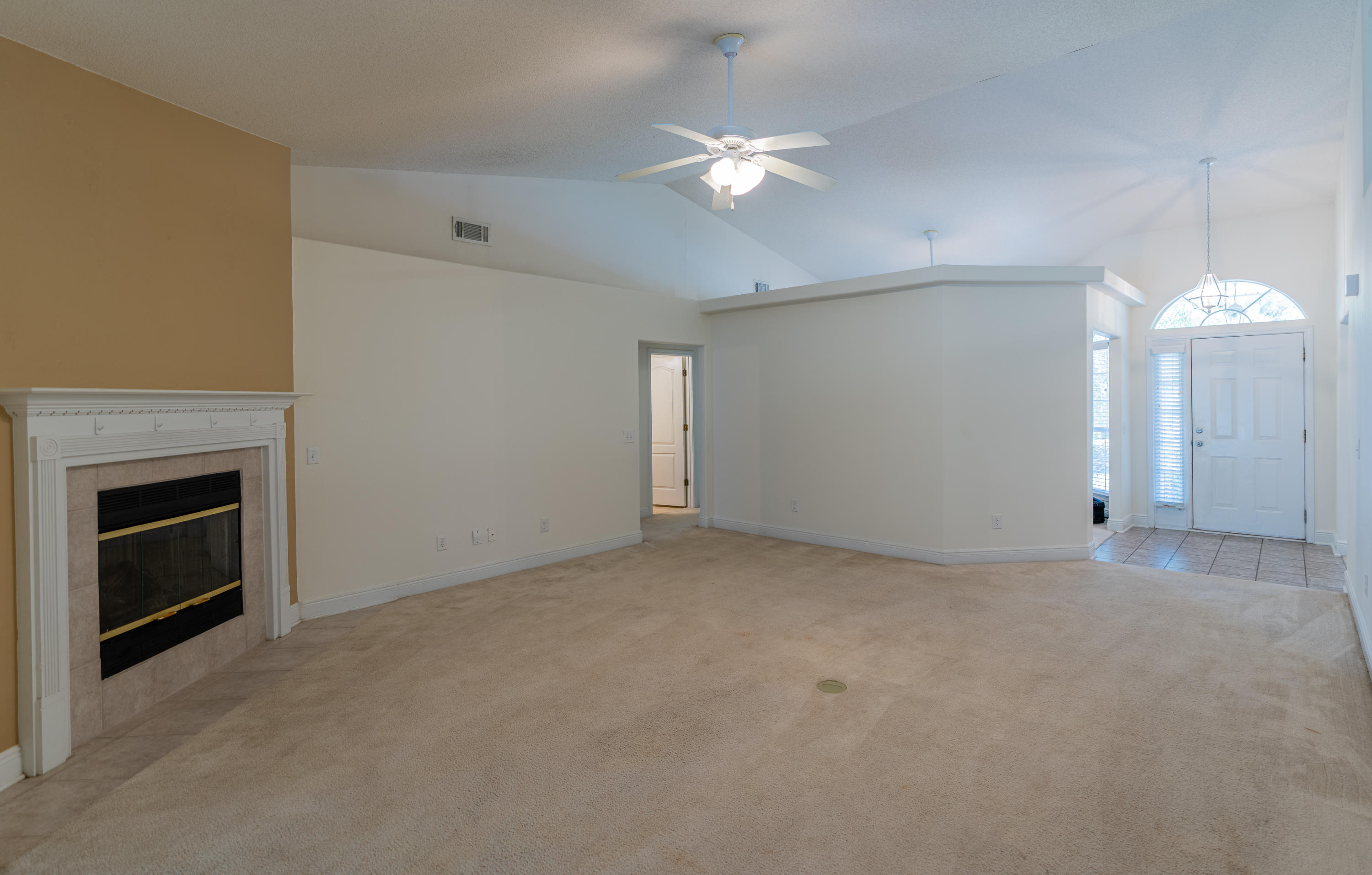 231 Foxchase Way Crestview, FL 32536 - Photo 8 of 30 an empty room with a fireplace and chandelier fan
