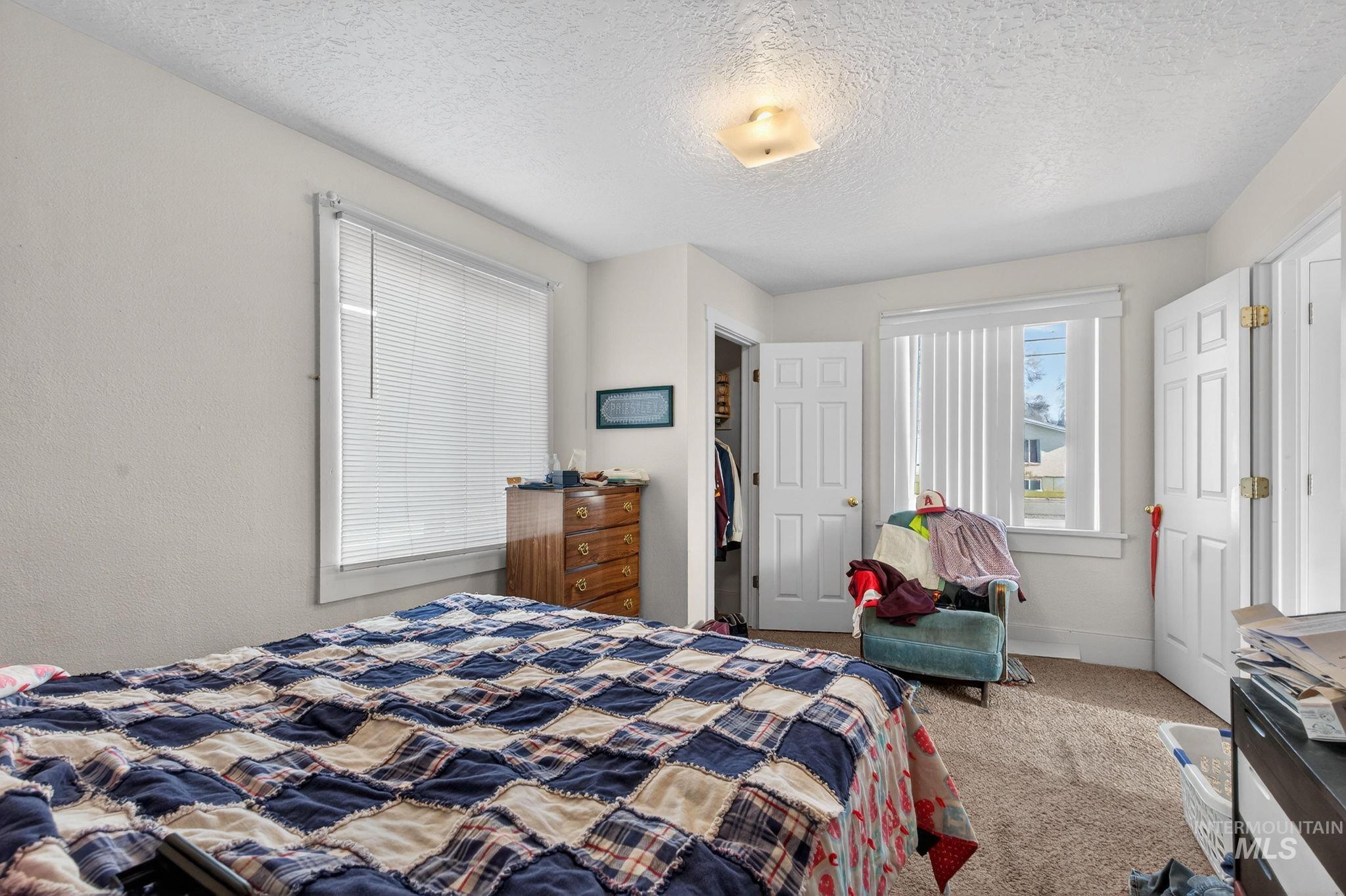 208 South 4th W Street Preston, ID 83263 - Photo 7 of 38 Bedroom featuring carpet floors, a textured ceiling, and a walk in closet