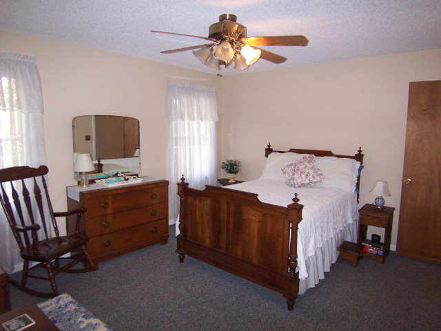 69 Lentz Road Macon, GA 31220 - Photo 4 of 12 a bedroom with a bed and a chandelier