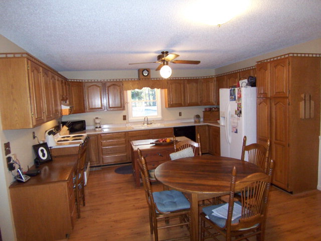 69 Lentz Road Macon, GA 31220 - Photo 9 of 12 a kitchen with stainless steel appliances granite countertop a stove a refrigerator a sink a dining table and chairs with wooden floor