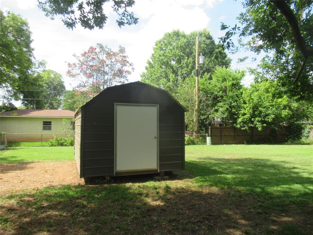 2513 Rosedale Place Bossier City, LA 71111 - Photo 8 of 13 Gabled storage shed with a white door, situated on a grassy lawn