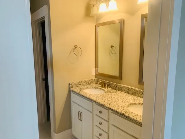 a bathroom with a granite countertop sink and a mirror