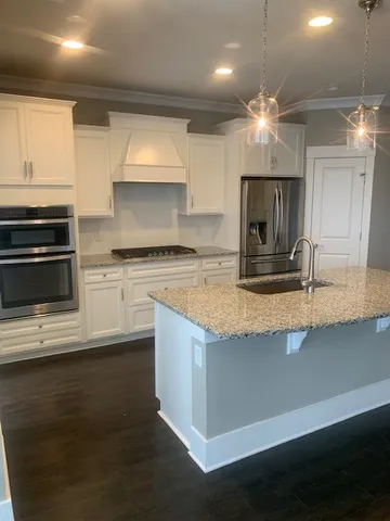 a kitchen with stainless steel appliances granite countertop a sink a stove and a microwave