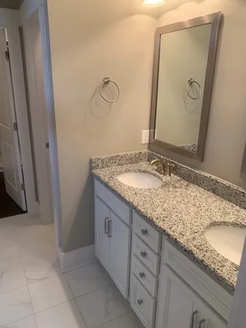 a bathroom with a granite countertop sink and a mirror