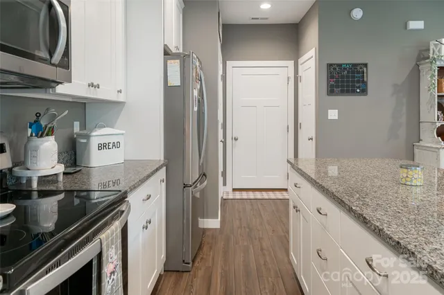 a view of a hallway with wooden floor and entryway