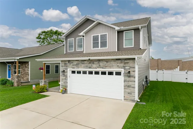 a front view of a house with a yard and garage
