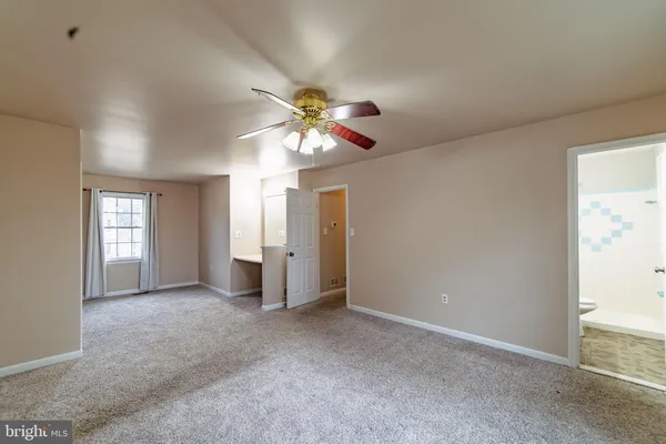 a view of a big room with windows and chandelier fan