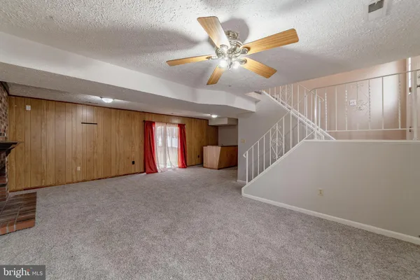 a view of an empty room with a fireplace and a window