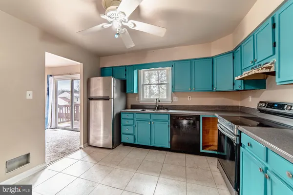 a kitchen with granite countertop a sink cabinets and stainless steel appliances