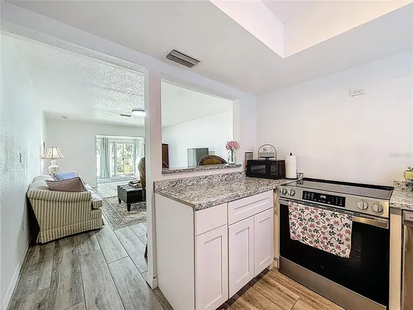 a kitchen with granite countertop a stove and cabinets
