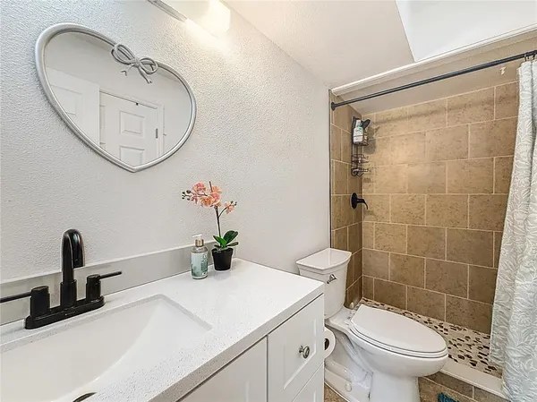 a bathroom with a sink a toilet and a mirror