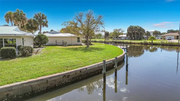 a view of a house with a yard and a pond