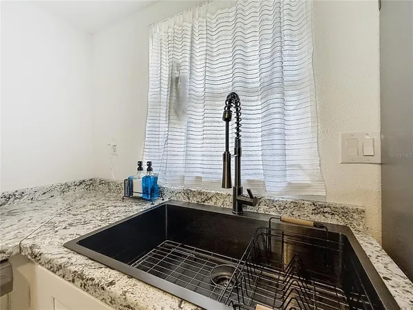 a kitchen with granite countertop a sink and a stove