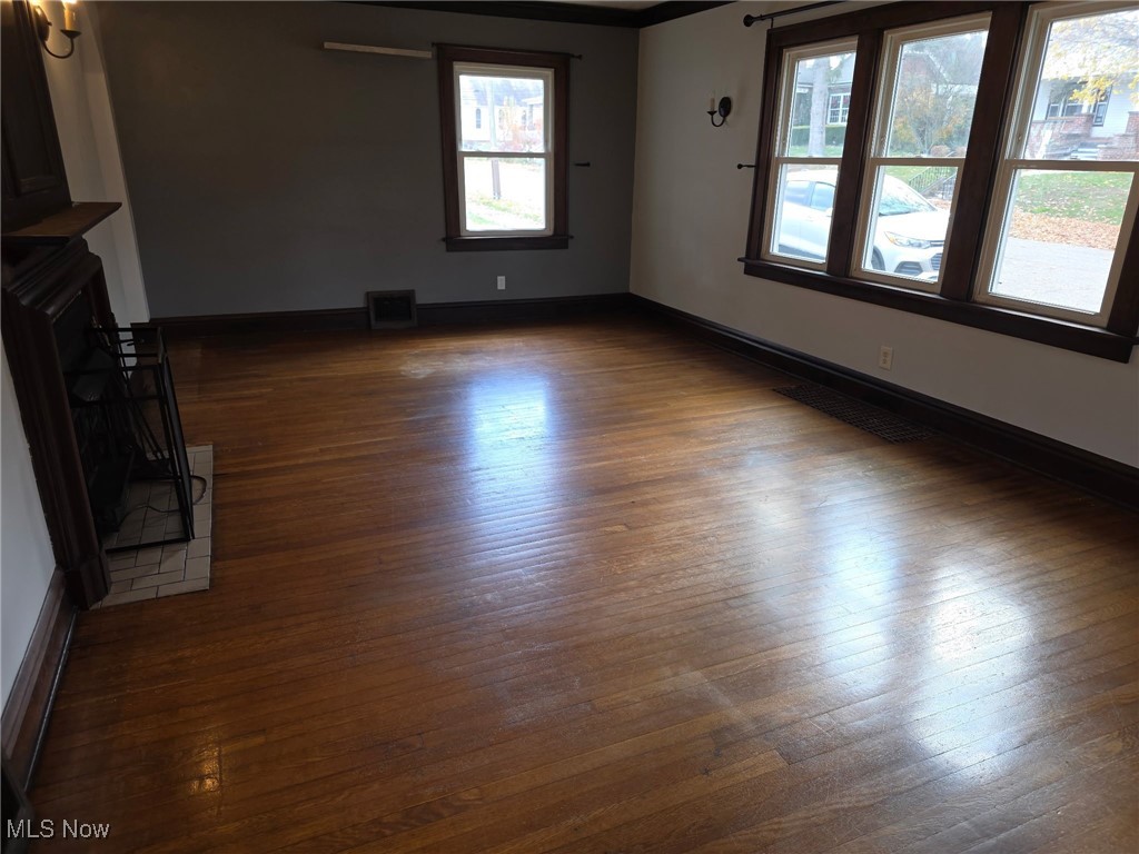 64 Sheldon Street Rittman, OH 44270 - Photo 3 of 37 Unfurnished living room with dark wood-style floors and a fireplace