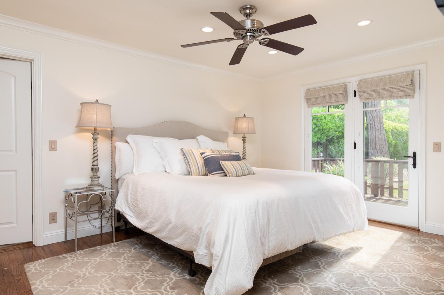 3115 Middle Ranch Road Pebble Beach, CA 93953 - Photo 15 of 19 a bedroom with a large bed and a chandelier