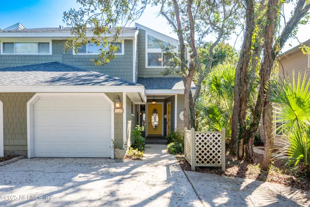 a view of a house with a door and a tree
