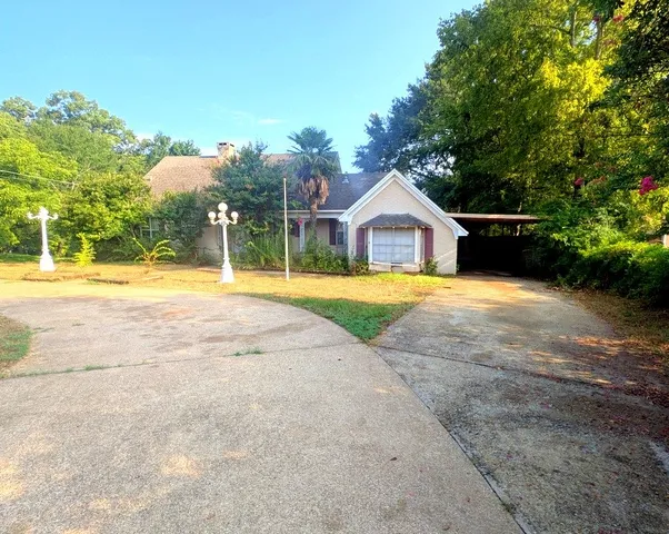 a view of a house with a backyard and a tree