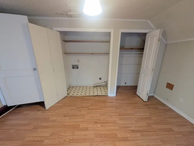 an empty room with wooden floor and closet