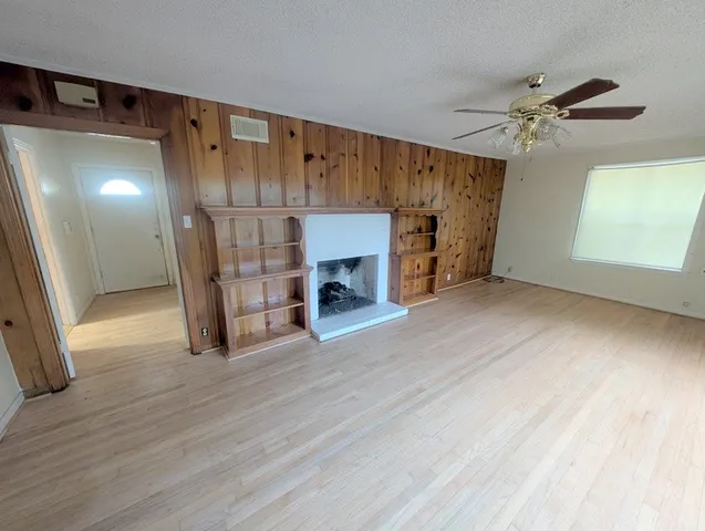 a view of a livingroom with wooden floor and a fireplace