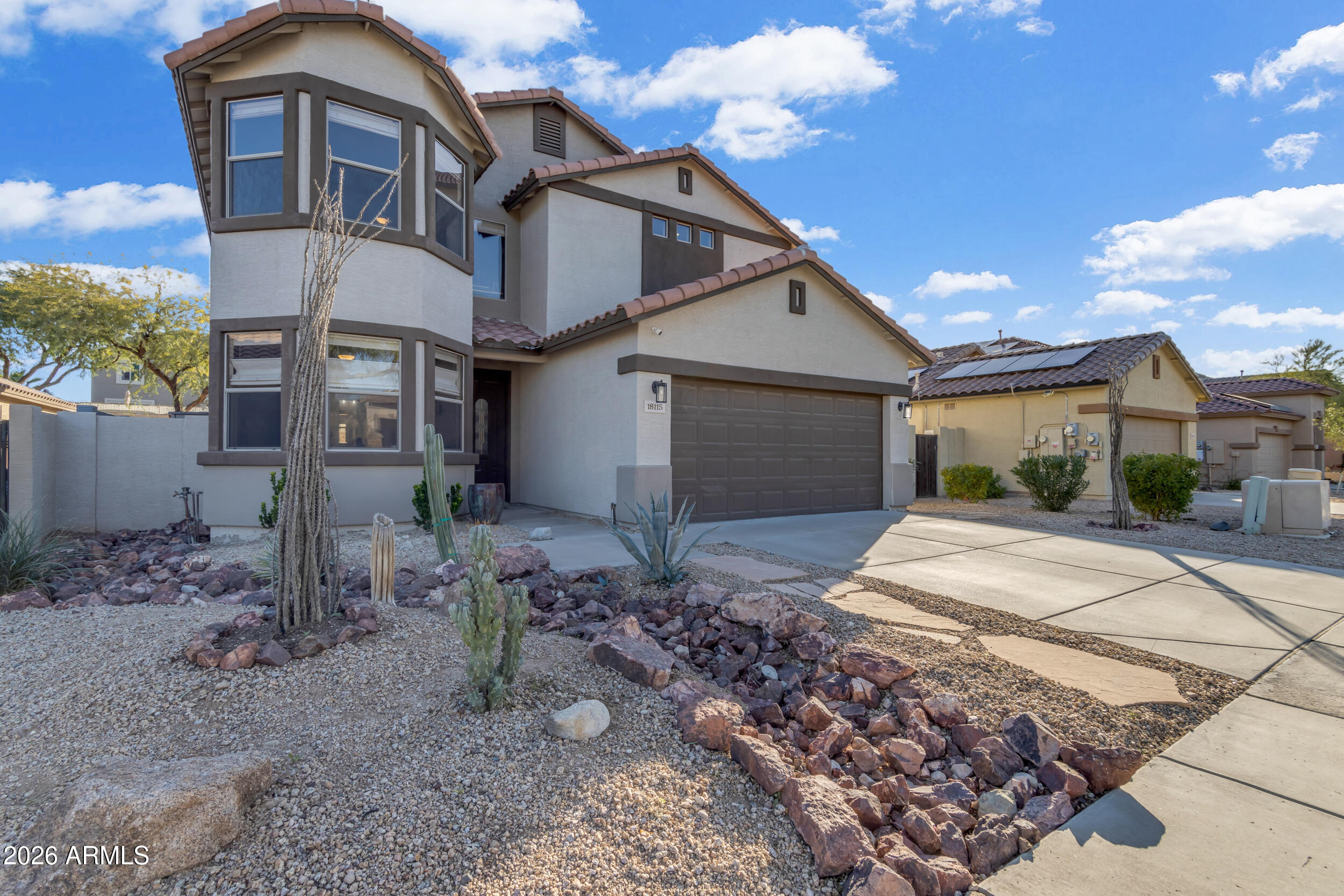 18115 West Cardinal Drive Goodyear, AZ 85338 - Photo 63 of 88 a view of a white house with large windows next to a yard
