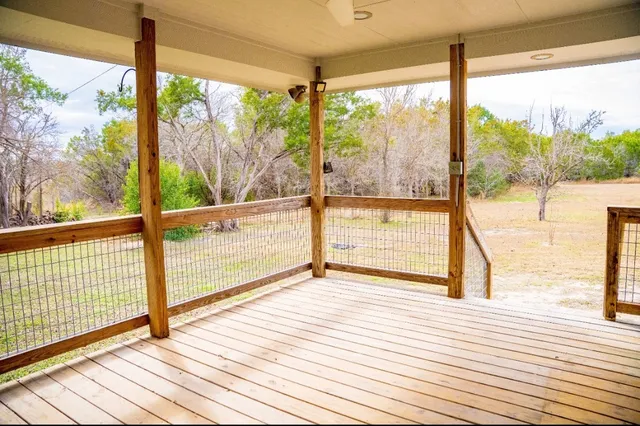 a view of empty room with wooden floor and windows
