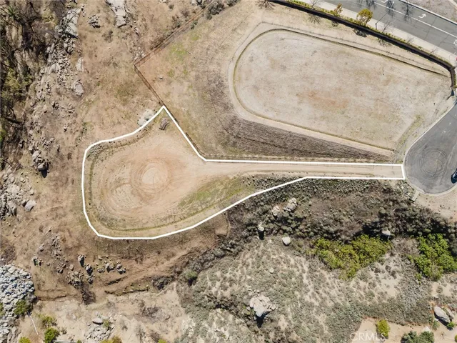 a view of a dry yard with wooden fence