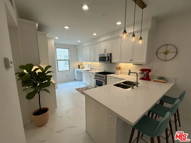 a kitchen with a table chairs sink and cabinets