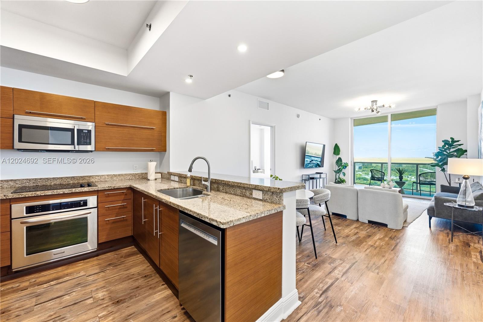 2641 North Flamingo Road, Unit 2605N Sunrise, FL 33323 - Photo 2 of 56 a kitchen with a sink stove and wooden cabinets