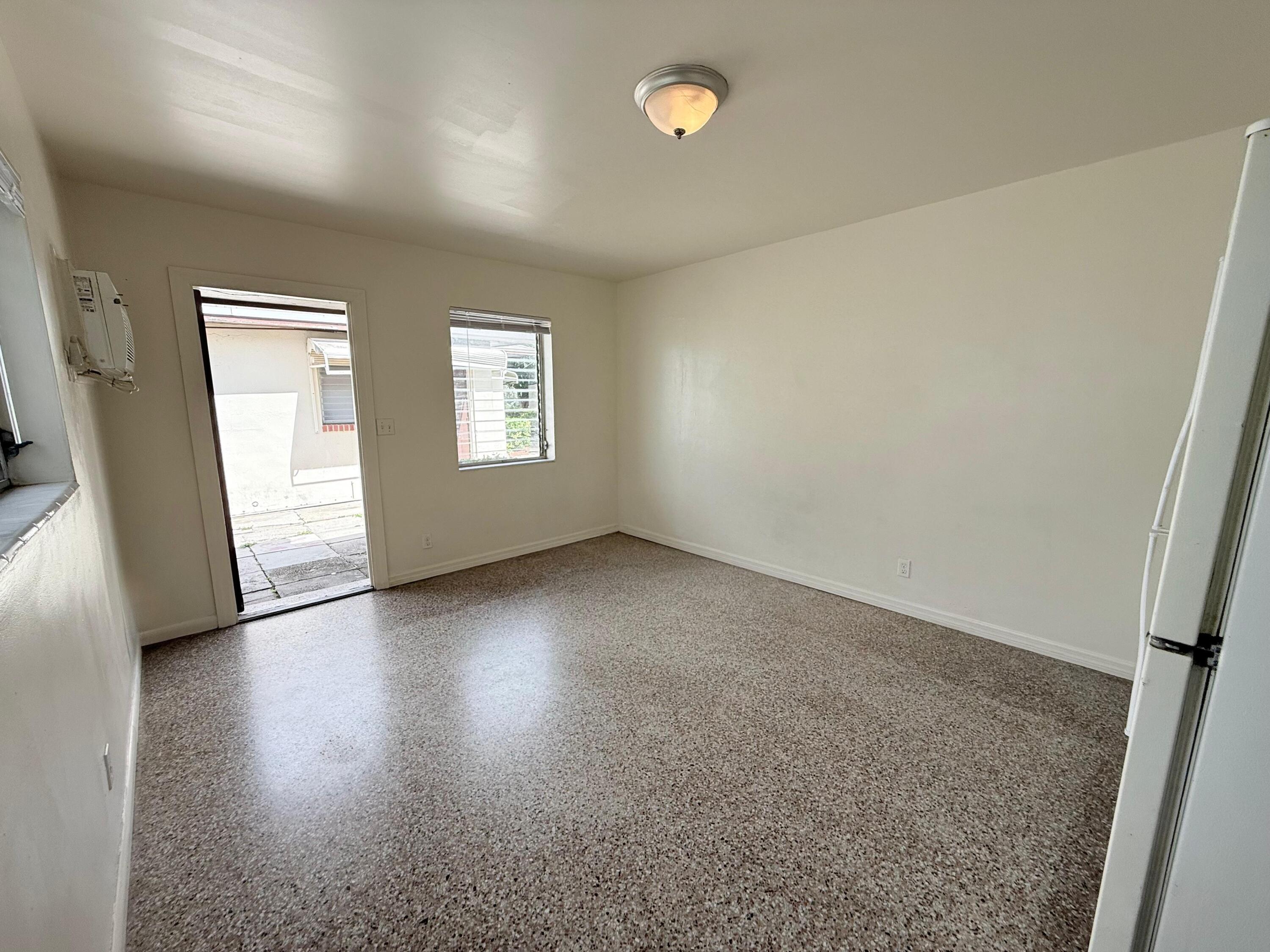 43 East 16th Street, Unit 4 Riviera Beach, FL 33404 - Photo 4 of 7 an empty room with wooden floor and windows