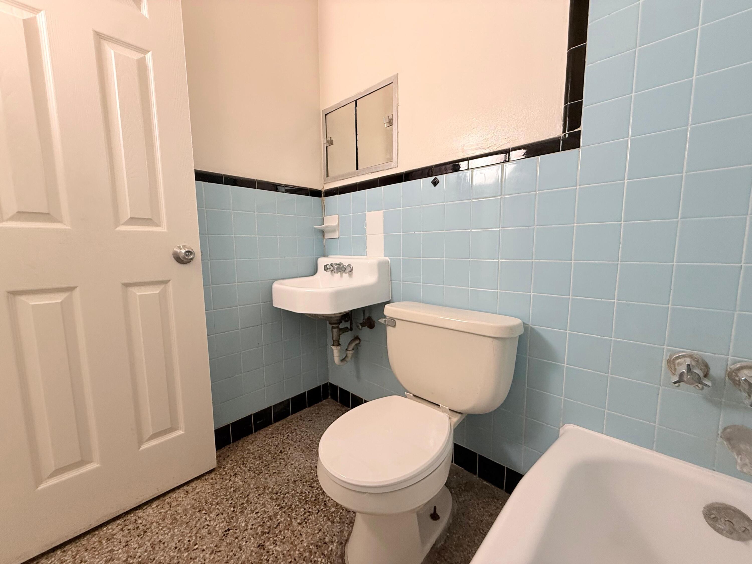 43 East 16th Street, Unit 4 Riviera Beach, FL 33404 - Photo 7 of 7 a bathroom with a toilet sink and mirror