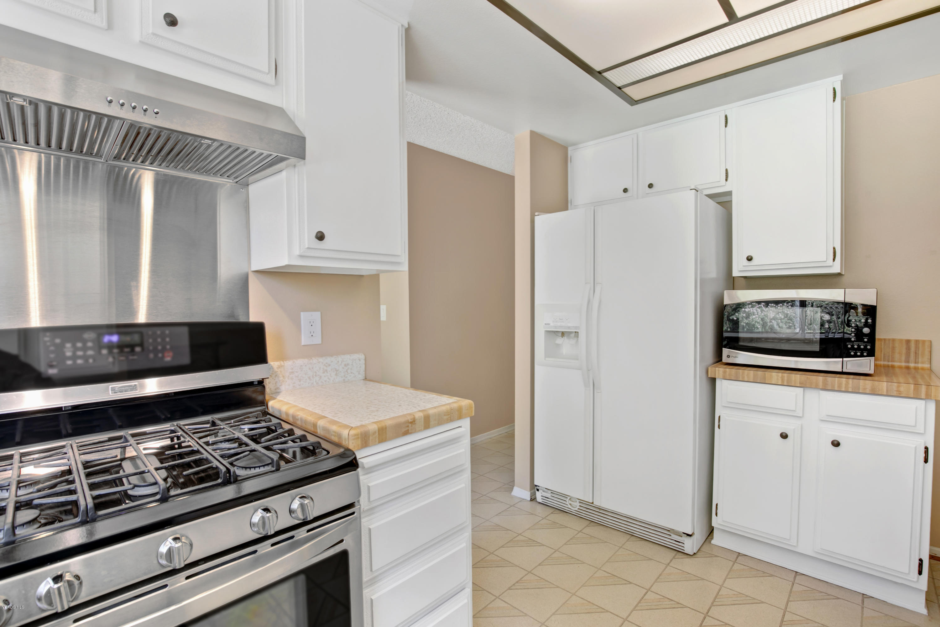 1291 Rambling Road Simi Valley, CA 93065 - Photo 11 of 75 a kitchen with white cabinets and appliances