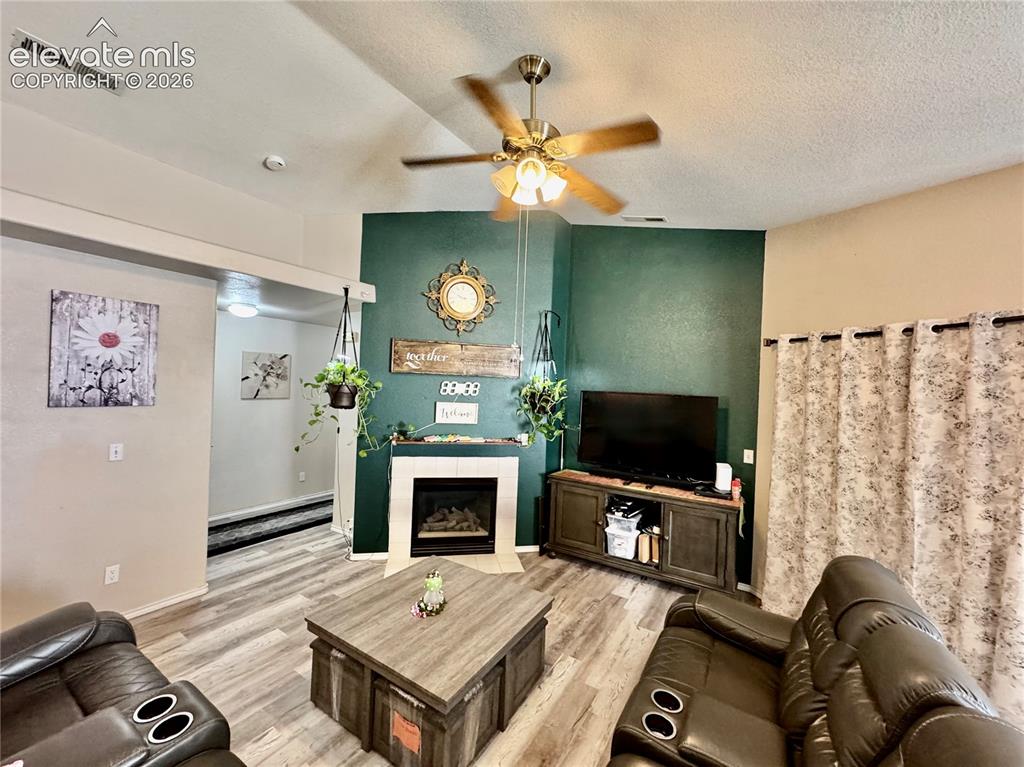 3748 Riviera Grove, Unit 203 Colorado Springs, CO 80922 - Photo 13 of 23 a living room with furniture a flat screen tv and a fireplace