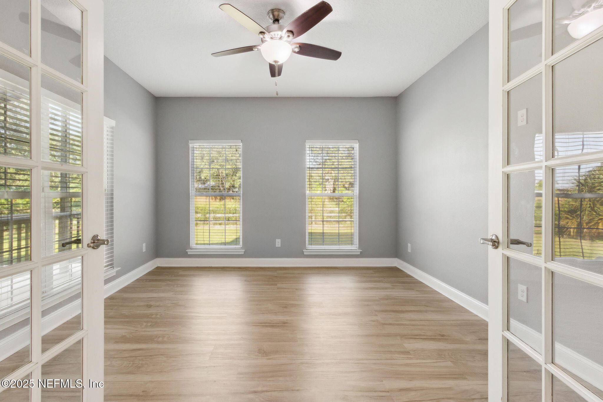 16199 Shellcracker Road Jacksonville, FL 32226 - Photo 11 of 40 a view of an empty room with a window and wooden floor