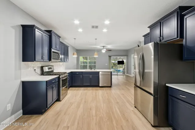 a kitchen with stainless steel appliances kitchen island granite countertop a refrigerator stove top oven and sink