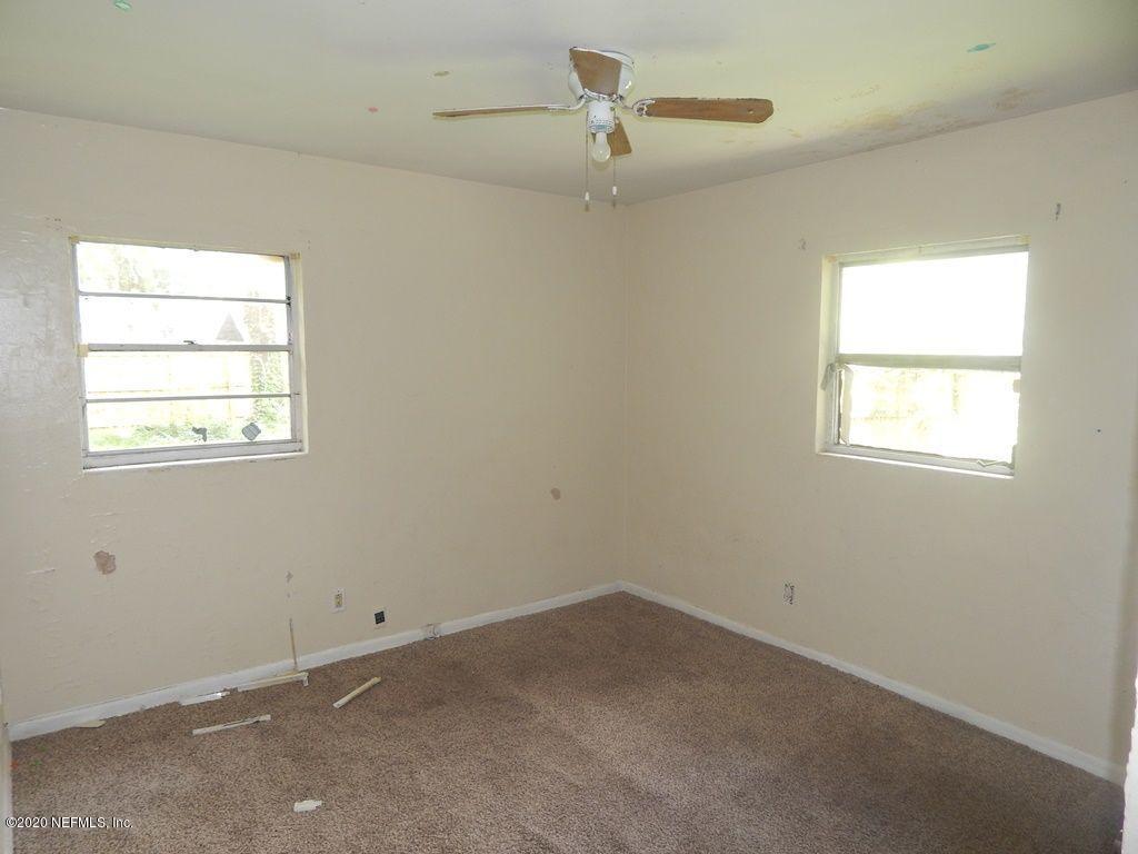 7514 Melvin Road Jacksonville, FL 32210 - Photo 6 of 7 an empty room with a window and ceiling fan