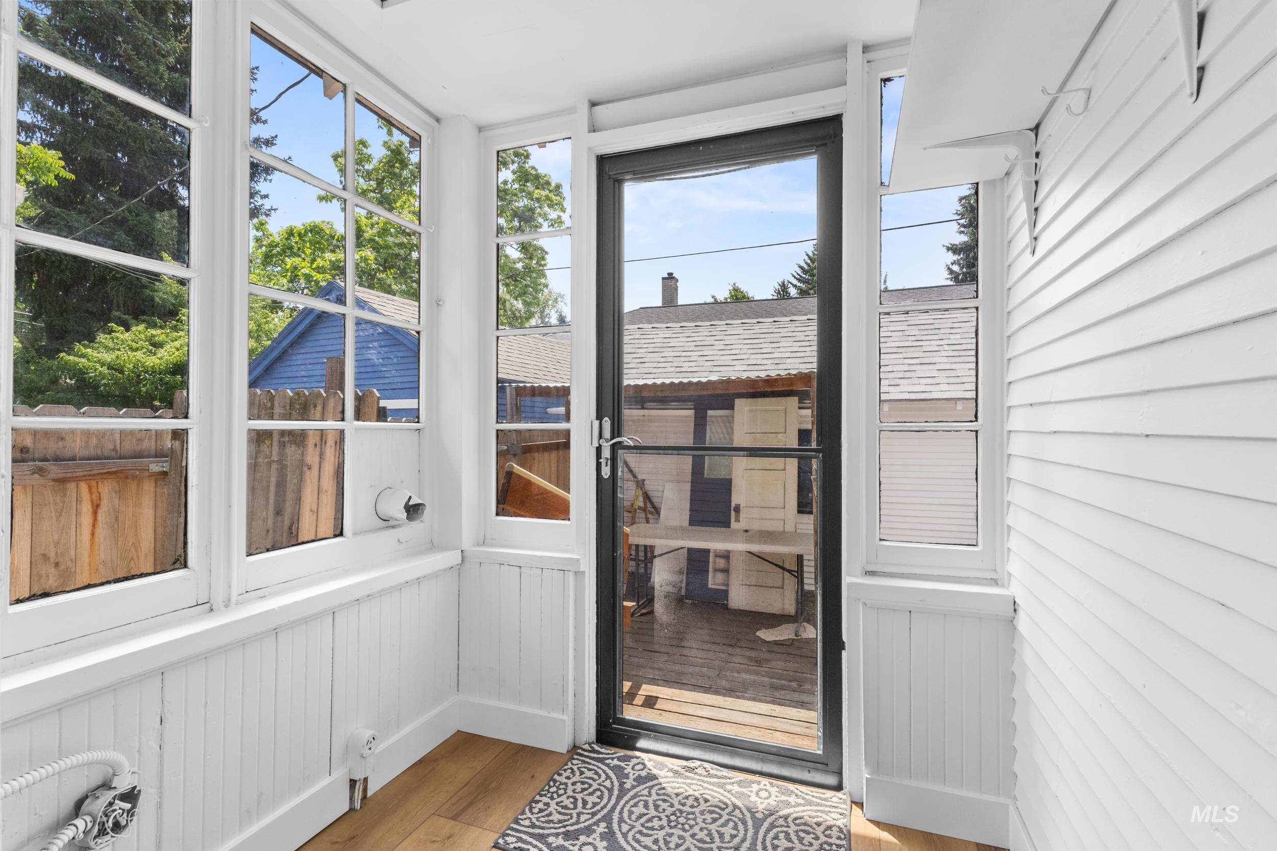 2119 West Brumback Street Boise, ID 83702 - Photo 22 of 30 Sunroom with abundant natural light from numerous windows, beadboard wainscoting, white shiplap siding, and wood-finish flooring