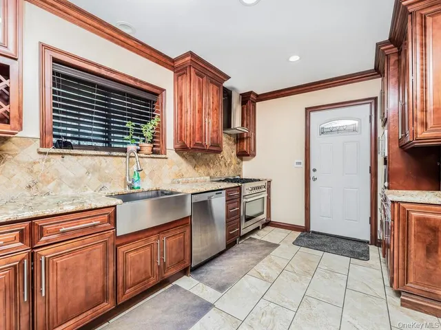 a kitchen with stainless steel appliances granite countertop a stove a sink and a microwave