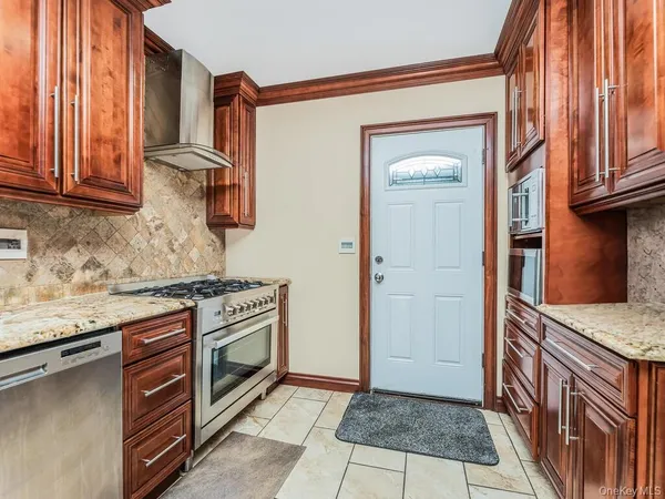 a kitchen with stainless steel appliances granite countertop a stove a sink and a refrigerator
