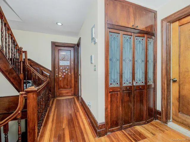 a view of a hallway with wooden floor and staircase