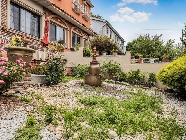 a view of a house with brick walls and a yard with potted plants