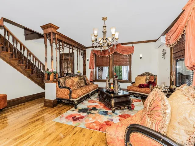 a living room with furniture chandelier and a wooden floor