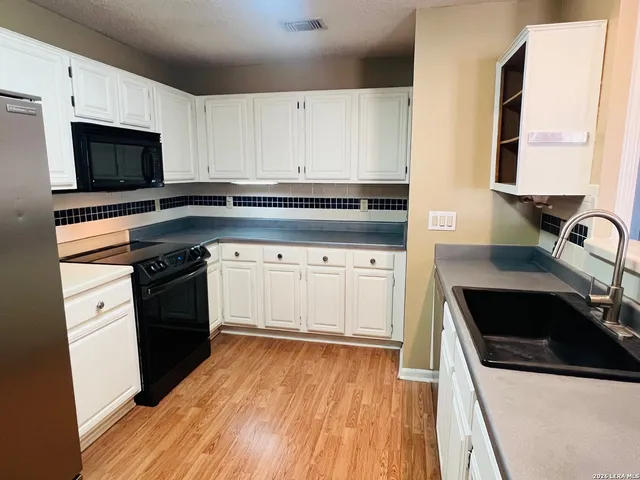 a kitchen with a sink stove and microwave